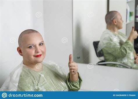 smiling shaved bald woman with bright make up in the hairdresserand x27 s chair shows class stock