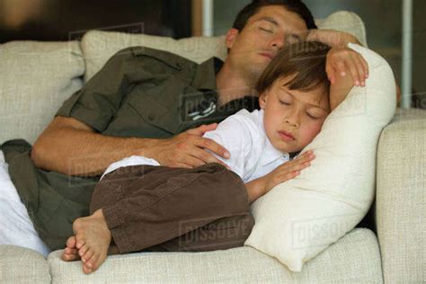 Father And Son Napping Together On Sofa Stock Photo Dissolve
