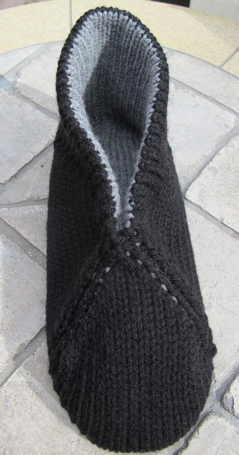 A Black Knitted Slipper Sitting On Top Of A Stone Floor