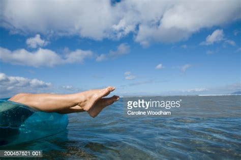 Mature Woman Floating On Inner Tube In Sea Low Section Side View Stock