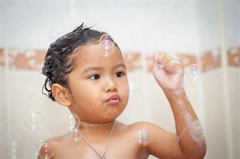 Niño Linda Niña Bañándose Y Jugando Con Burbujas En El Baño Foto Premium