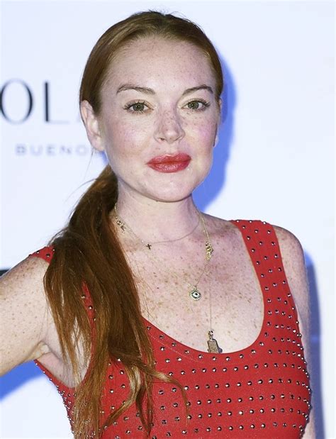 lindsay lohan flashes bra at christmas party in sheer top and black ankle boots