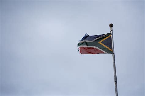 bandera sudafricana tattered ondeando en el viento sobre el fondo sombrío foto de stock y más