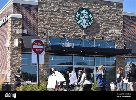 Starbucks workers walk off the job holding placards to support the