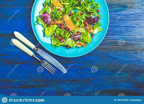 Fresh Healthy Salad With Lettuce Chicken And Pomegranate In Blue Plate