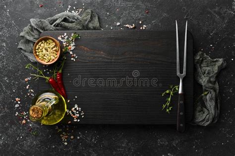 Dark Kitchen Wooden Board With Cutlery On A Black Stone Background