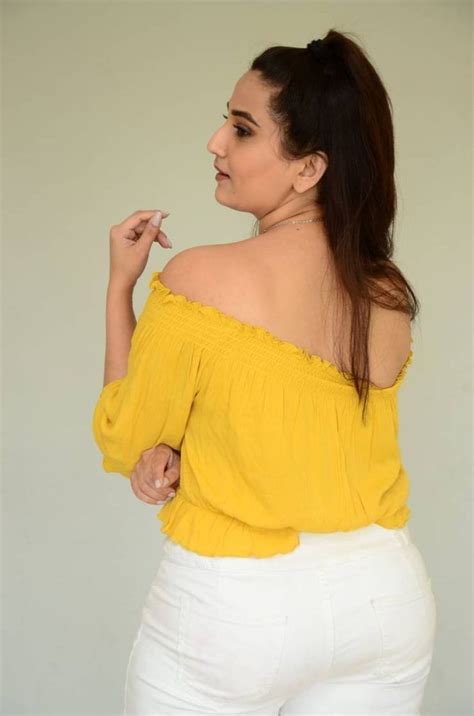 A Woman In White Pants And A Yellow Top Is Holding Her Finger To Her Lips