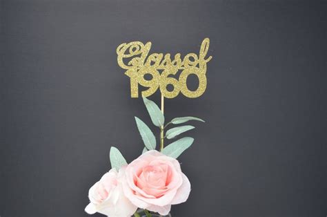 A Cake Topper That Says Class 1960 With Flowers