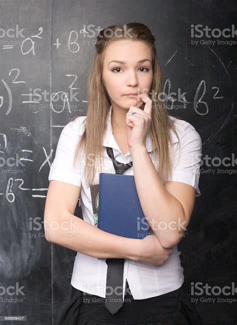 Portrait Of Happy Cute Student With Book In Classroom Stock Photo