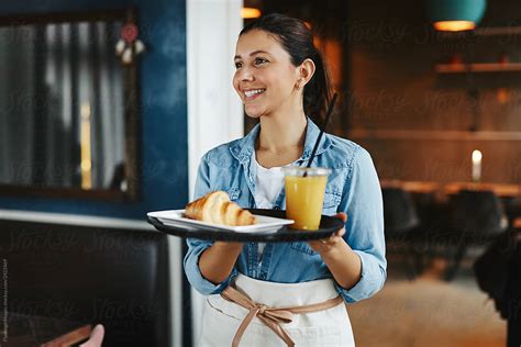 Smiling Waitress Carrying An Order Of Food In A Cafe By Flamingo Images