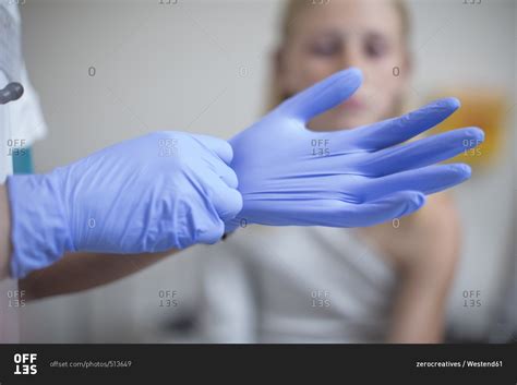 Doctor Putting On Blue Latex Gloves Stock Photo Offset
