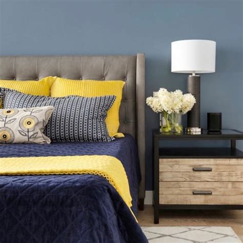 A Bedroom With Blue Walls And Yellow Bedding Two Nightstands On Either