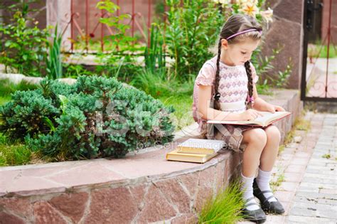 Schoolgirl Reading A Book Outdoors Stock Photo Royalty Free Freeimages