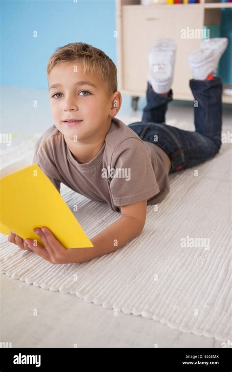 Cute Little Boy Sitting On Floor Reading In Classroom Stock Photo Alamy