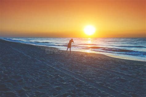 A Woman Stands On The Beach During Sunset Stock Photo Image Of Female