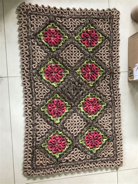 A Crocheted Rug With Flowers On It