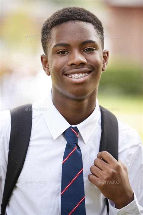 Portrait Of Male Teenage Student In Uniform Outside Buildings Stock