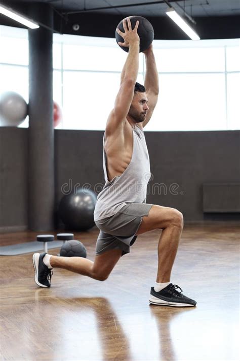 Fit And Muscular Man Exercising With Medicine Ball At Gym Stock Image