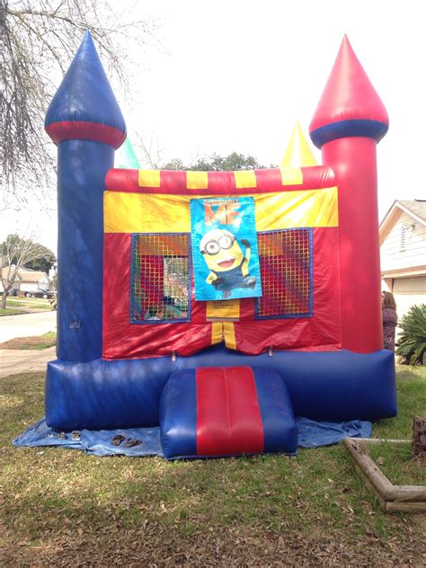 Colorful Castle Bounce House With Despicable Me Banner Minion Party
