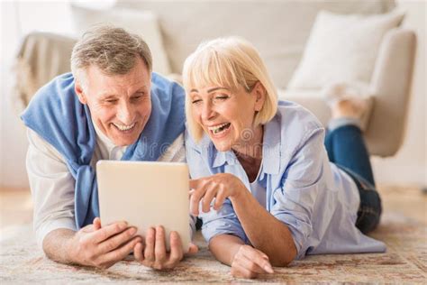 Senior Couple Using Tablet Pc Having Video Call With Grandkids Stock