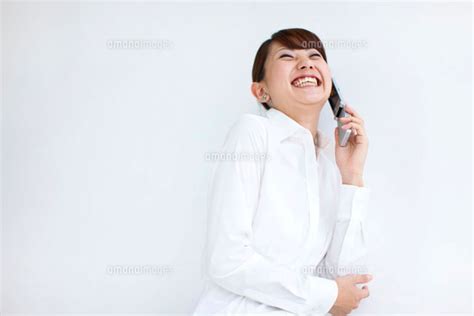 携帯電話で話している笑顔のビジネスウーマン[07800011450]の写真素材・イラスト素材｜アマナイメージズ