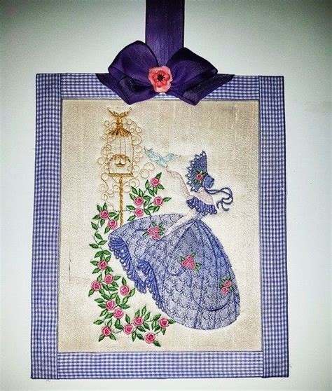 A Blue And White Wall Hanging With A Purple Ribbon On Its Side