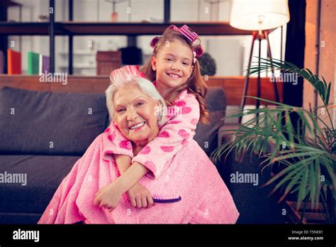 Happy Granddaughter Hugging Her Granny After Putting Hair Rollers Stock