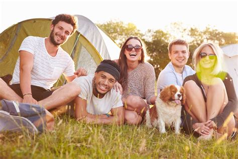 Group Of Friends Relaxing Outside Tents On Camping Holiday Stock Photo