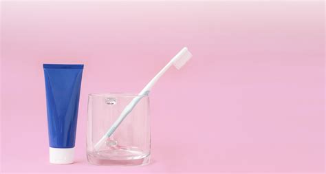 Blue Toothpaste Tube And Toothbrush In Transparent Glass With Gradient