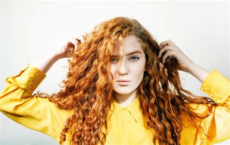 Premium Photo Attractive Ginger Girl Touching Her Curly Hair On The White Background
