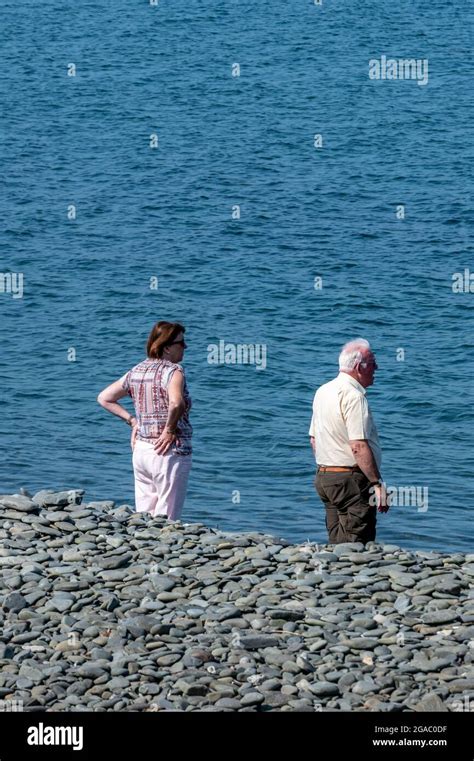 older couple together on the coast retired couple at the beach middle aged couple standing on