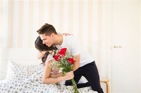 Free Photo Woman On Bed Thanking Man For Bouquet