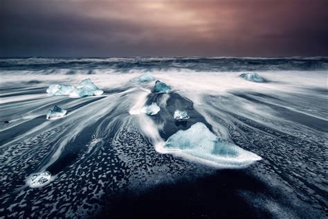 Black Sand Beach In Iceland Is Dotted With Turquoise Icebergs