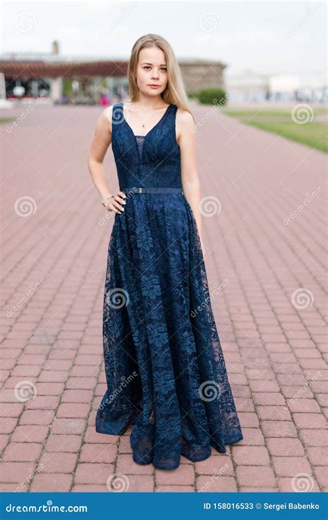 Slender Blonde Girl In Elegant Dark Blue Floor Length Dress On The Pavement Stock Image Image
