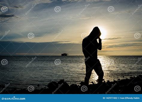 Silhouette Of A Man Standing Alone And Posing On Seashore With