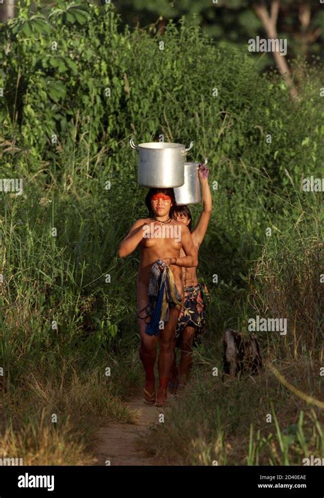 las mujeres indígenas yawalapiti obtienen agua potable del río tuatuari cerca de su aldea en la
