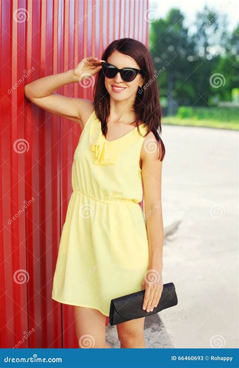 Fashion Smiling Woman Wearing Yellow Dress And Sunglasses With Handbag