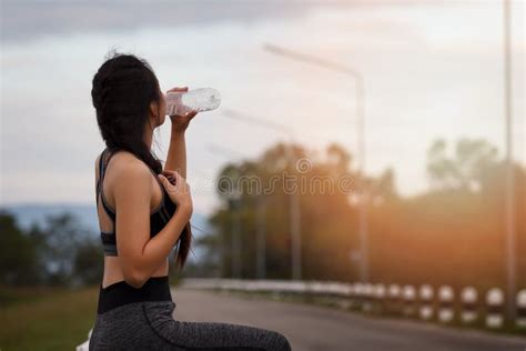 Attractive Healthy Fitness Girl Drinking Water After Workout Runner