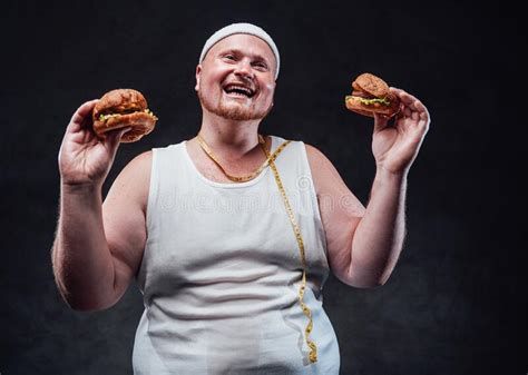 Fat Man With Two Hamburgers In His Hands Smiling And Laughing Stock