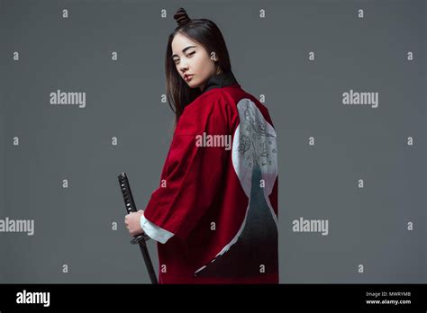 Young Woman In Traditional Japanese Kimono Holding Katana And Looking