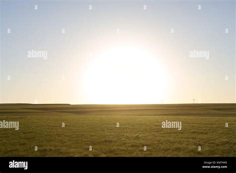 Tranquil rural scene with a green hill against clear sunny sky at