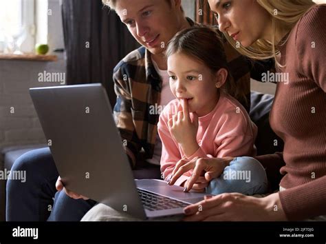 Felices Padres De Familia E Hija Pequeña Usando El Ordenador Portátil