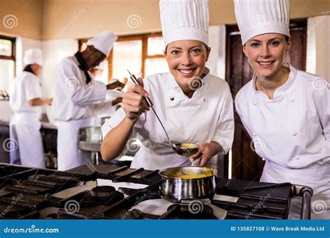 Female Chefs In Commercial Kitchen Wearing White Uniforms Royalty Free Stock Image