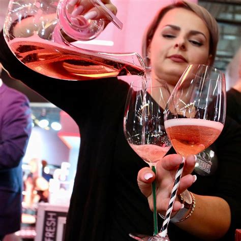A Woman Pouring Pink Wine Into Two Glasses