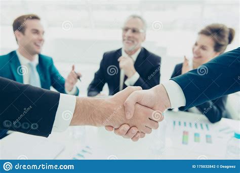 Close Up Of Two Businessmen Shaking Hands Above Signed Contract Stock Photo Image Of