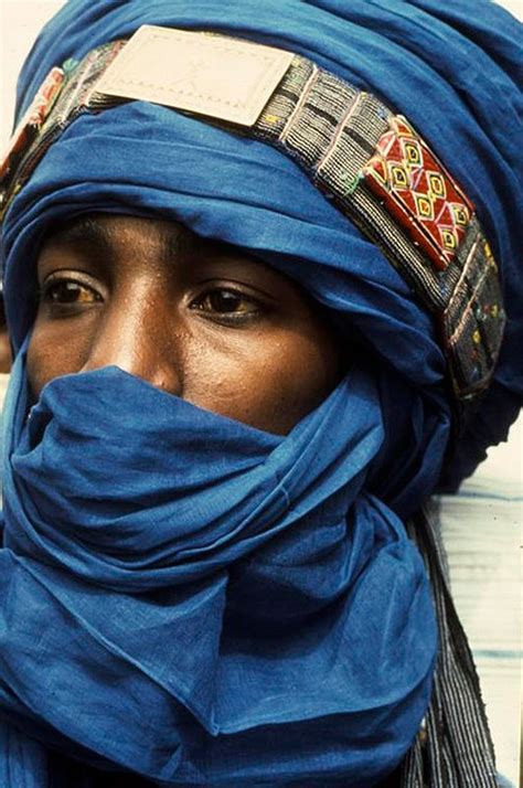 A Woman Wearing A Blue Scarf And Head Covering