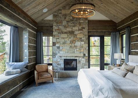 A Bedroom With Stone Fireplace And Large Windows