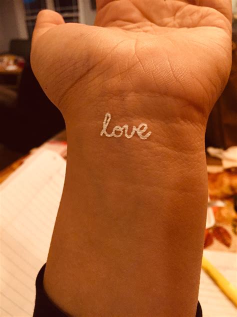 The Word Love Written In White Ink On A Womans Left Arm And Wrist