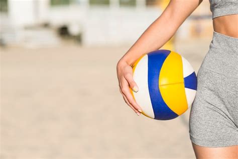 free photo front view of female volleyball player on the beach holding ball with copy space