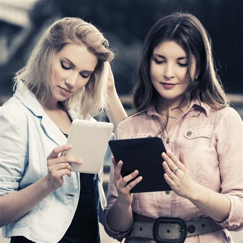 Dos Mujeres De La Moda De Los J Venes Que Usan La Tableta Al Aire Libre